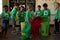 Group of schoolchildren holding color coded recycling bins and bags  in an elementary school classro