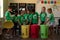 Group of schoolchildren holding color coded recycling bins and bags in an elementary school classroo