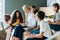 group of schoolchildren listening to their teacher while sitting