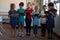 Group of schoolchildren standing in a line and using tablet computers