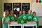 Group of schoolchildren wearing green t shirts with a white recycling logo on them