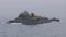 Group sea lions on rocky cliff and birds flying over ocean water