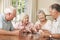 Group Of Senior Couples Enjoying Game Of Cards At Home