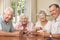 Group Of Senior Couples Enjoying Game Of Cards At Home