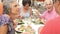 Group Of Senior Friends Enjoying Meal In Outdoor Restaurant