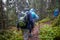 Group of senior tourists hiking in rainy forest