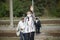 Group of senior travelers with masks on their faces cross the railway tracks