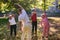 A group of seniors follows a trainer, engaging in outdoor exercises in the park, as they collectively strive to maintain