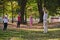 A group of seniors follows a trainer, engaging in outdoor exercises in the park, as they collectively strive to maintain