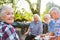 Group of seniors in the garden while having coffee