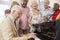 Group Of Seniors Standing By Piano And Singing Together