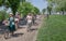 Group of seniors and young women in old fashion style cycling with vintage bicycle at festival Retro Cruise