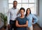 Group of serious business people pose arms folded in office, diverse trio