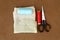 Group of sewing tools and items for knitting and weaving placed on a brown colour woven paper board. DIY Art and craft background
