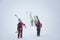 Group of skiers carries skis and equipments to the track on a slope for skiing on Mount Asahi Asahidake mountain during snowfall