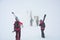 Group of skiers carries skis and equipments to the track on a slope for skiing on Mount Asahi Asahidake mountain during snowfall