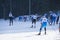 A group of skiers climbs up the snow-covered ski track defocused .