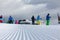 A group of skiers in colored jackets at the top of the final station of the lift. Ski slope in winter on a sunny day. Alpe Cermis,