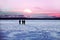 A group of skiers crosses a frozen lake