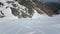 A group of skiers in a skitour stands on a snowy slope in the mountains. Ski touring freeride aerial view