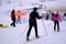 Group, skiers and snowboarders on skis at foot of snowy mountain, preparation for ascent from slope in Levi ski resort, tourism,