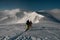 group of skiers walking at snow trail on snow-covered mountain range