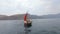 Group of slender models in bikinis relaxing on the luxury yacht with red sails in the open sea