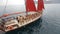 Group of slender models in bikinis relaxing on the luxury yacht with red sails in the open sea