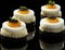 A group of small cakes with eggs on top, AI