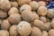 Group of small whole fresh brown coconuts on retail market