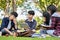 A group of smart young Asian college students doing their project together in the campus`s park