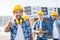 Group of smiling builders in hardhats outdoors