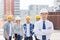 Group of smiling builders in hardhats outdoors