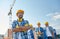 Group of smiling builders in hardhats outdoors