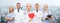 Group of smiling doctors with red heart shape