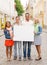 Group of smiling friends with blank white board