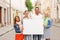 Group of smiling friends with blank white board