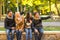 Group of smiling friends waving hands in city park