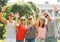 Group of smiling friends waving hands outdoors