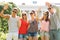 Group of smiling friends waving hands outdoors