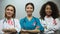 Group of smiling nurses with pink ribbons, breast cancer awareness, treatment