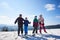 Group of smiling people on skis and snowboard in deep snow on background of blue sky and mountains.