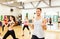 Group of smiling people working out with barbells