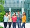 Group of smiling teenagers showing triumph gesture