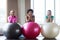 Group of smiling women with exercise balls in gym