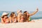 Group of smiling women with smartphone on beach