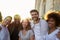 Group of smiling young adult friends embracing in the street