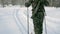 Group of soldiers run on skis in the woods with weapons. Clip. Soldiers with AK-47 rifles and grenade launchers running