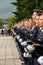 Group of soldiers wearing matching uniforms and hats stand in a neat line during the parade