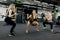 Group of sports strong people make sport exercise with barbell. Attractive women and handsome muscular man trainer are